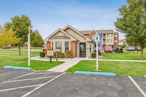 A parking lot in front of a building with a flag on a pole.
