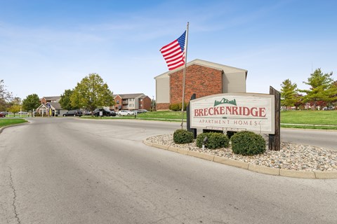 A street view of Breckenridge Apartment Homes with a flag on a pole.