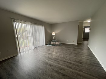 an empty living room with a sliding glass door - Photo Gallery 22