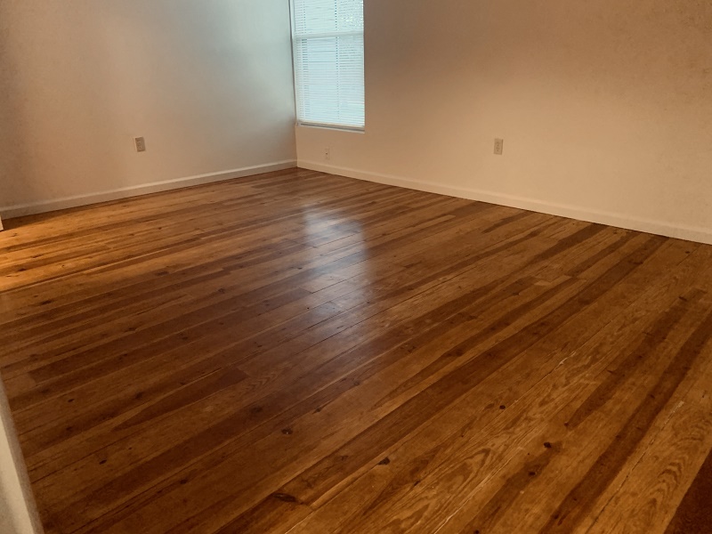 an empty living room with wooden floors