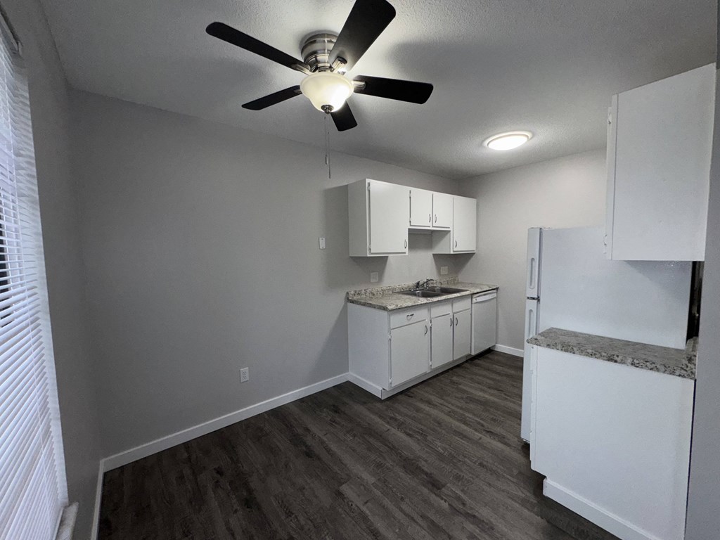 a kitchen with white cabinets and a ceiling fan
