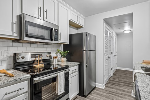 A kitchen with a black stove top oven and a black microwave above it.