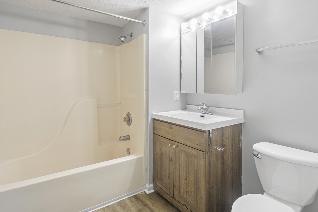a bathroom with a toilet sink and tub and a mirror