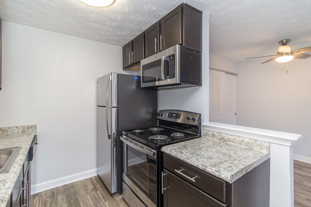 an updated kitchen with stainless steel appliances and granite counter tops