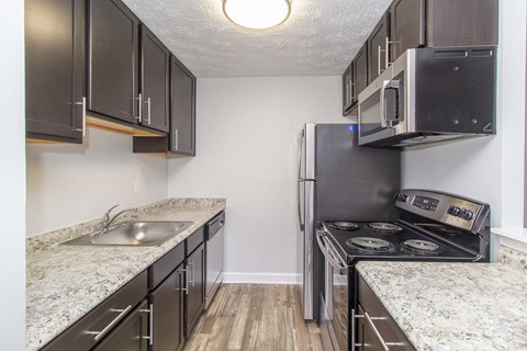 a kitchen with granite counter tops and a stainless steel refrigerator
