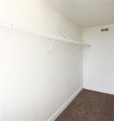 an empty room with a white wall and a white closet