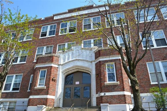 a red brick building with a tree in front of it