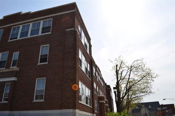 a red brick building with a orange cone in front of it