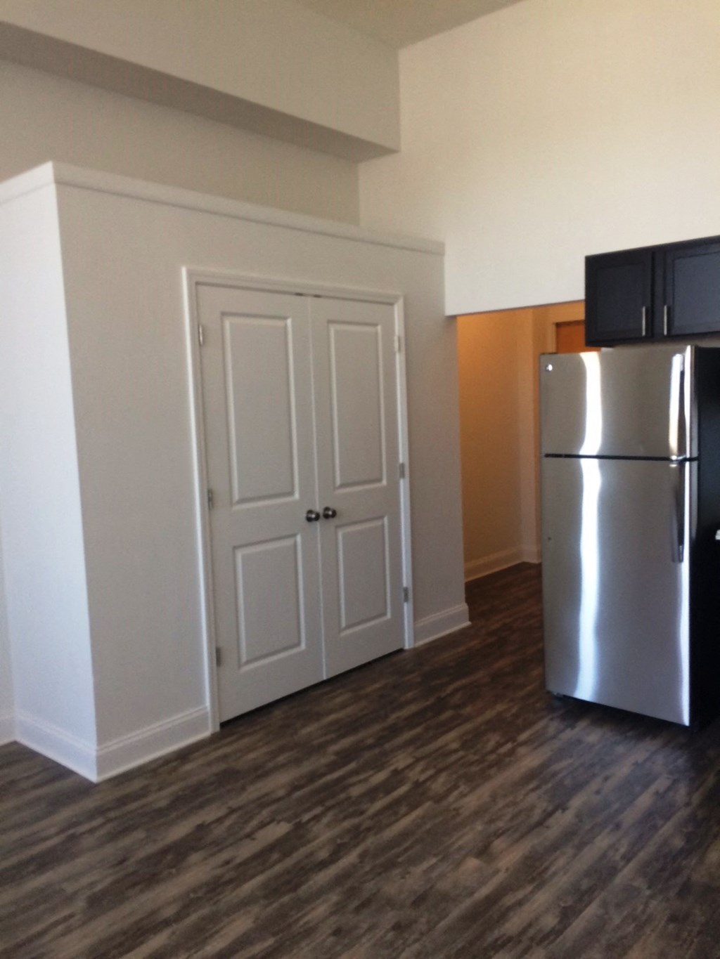 an empty room with a refrigerator and a door