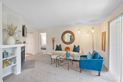 A living room with a blue couch and a fireplace.