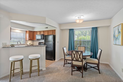 A kitchen with a black refrigerator and white cabinets.