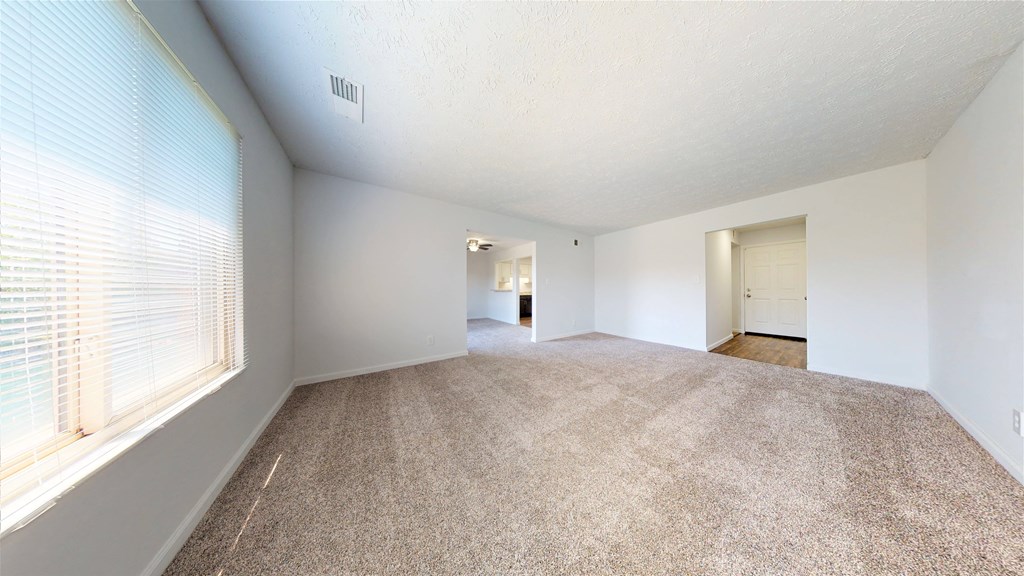 a bedroom with a large window and a carpeted floor  at Lawrence Landing, Indianapolis, Indiana