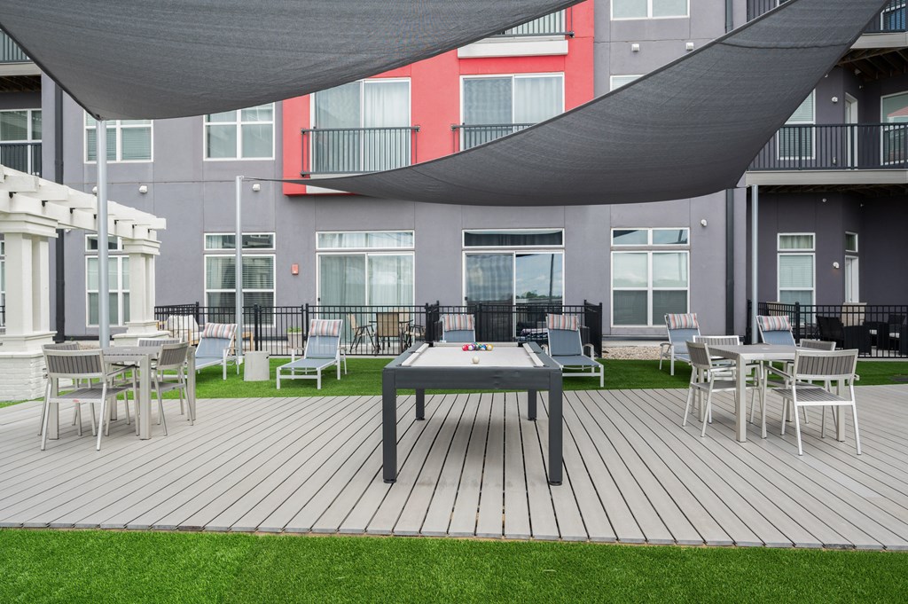 West Chester OH pet Friendly Apartments - Liberty Center - Outdoor Recreation Area with Pool Table, Lounge Chairs, Tables, Egg Chairs, Turf, Fire Pit, and Canopy Cover