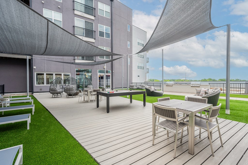 a patio area with tables and chairs and a building in the background