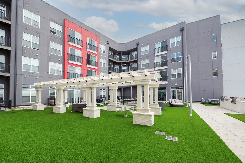 a green lawn in front of an apartment building