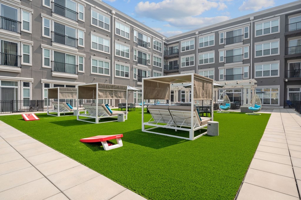 an exterior view of an apartment building with lawn and swing sets