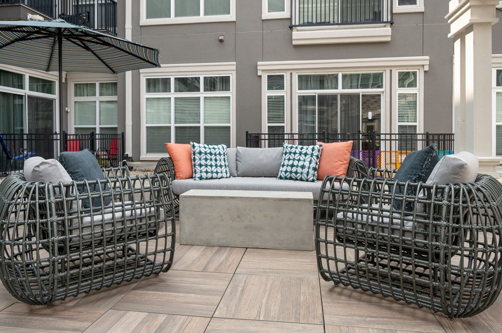 a patio with a couch and chairs and an umbrella