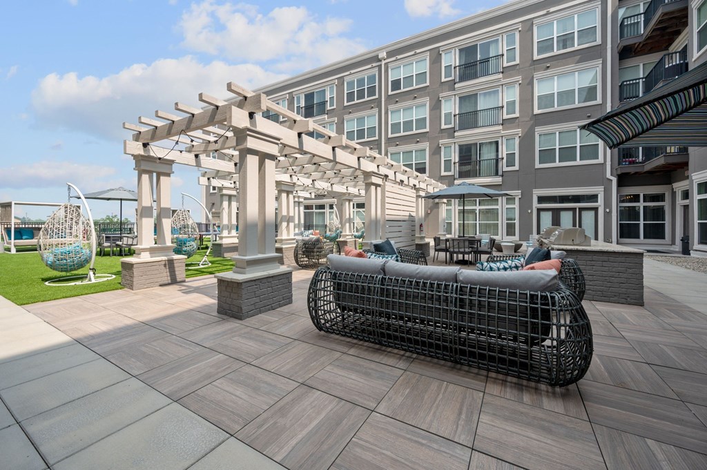 a patio with furniture and a building in the background