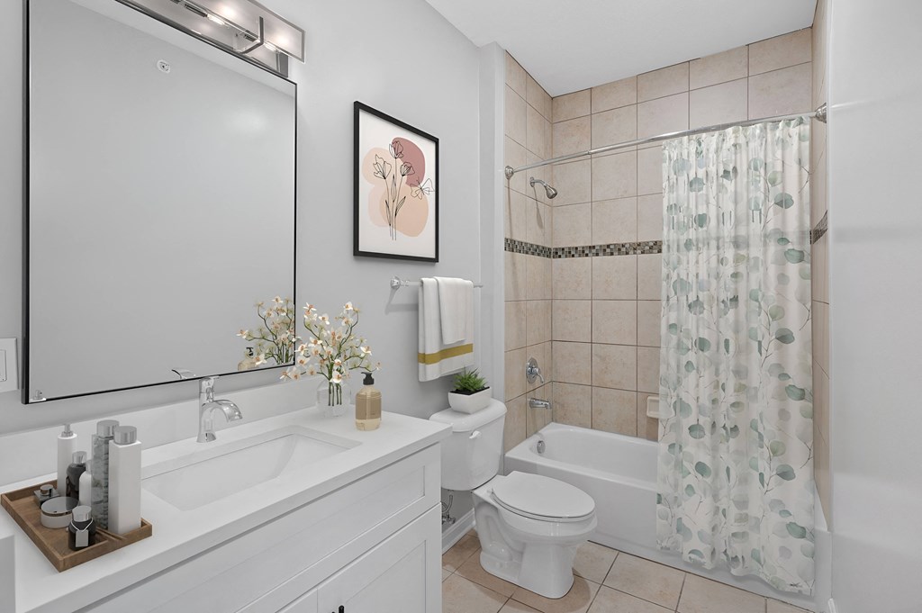 a white bathroom with a shower toilet and sink at Monmouth Row Apartments, Newport, KY, 41071