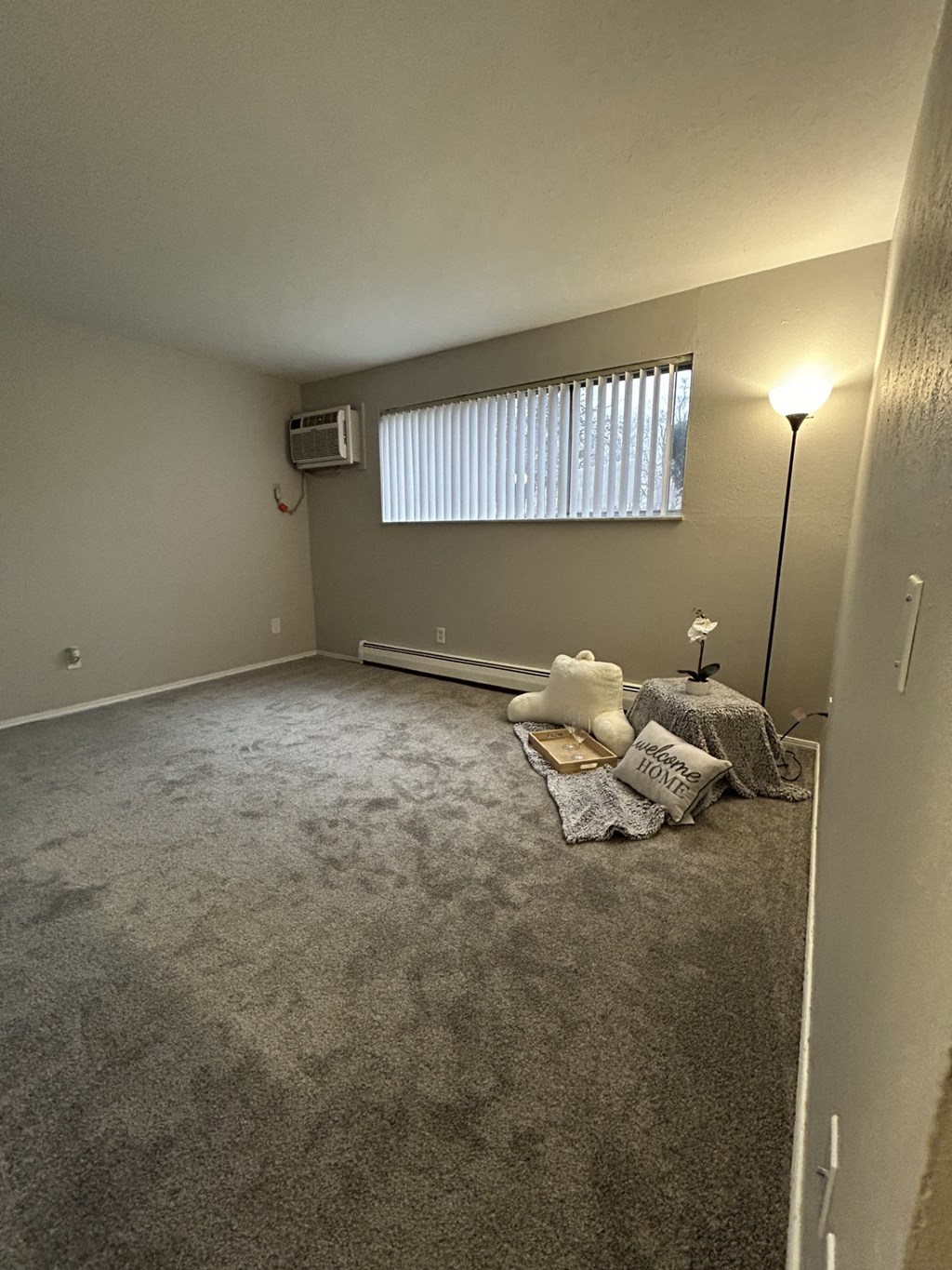 an empty living room with a couch and a window