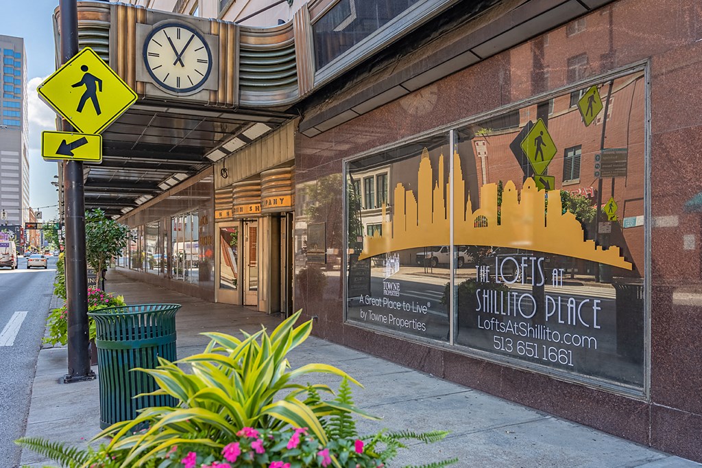 a street view of a building with a clock on the side of it