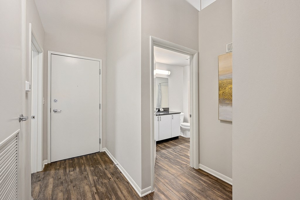 a bedroom with a door to a bathroom and a hallway with a bathroom door open