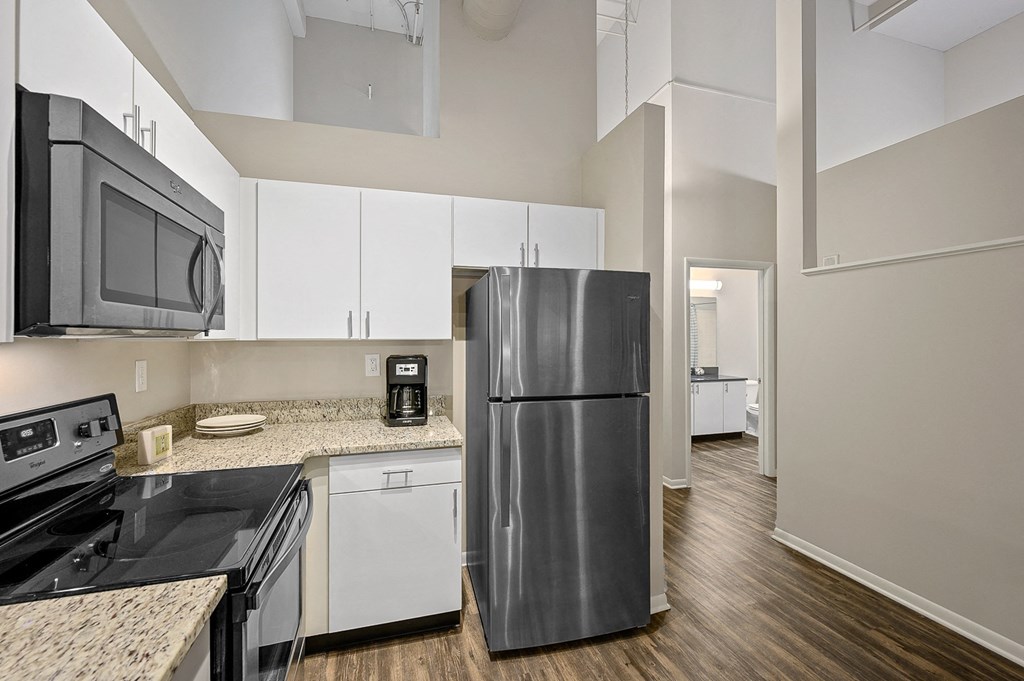 a kitchen with white cabinets and a black refrigerator