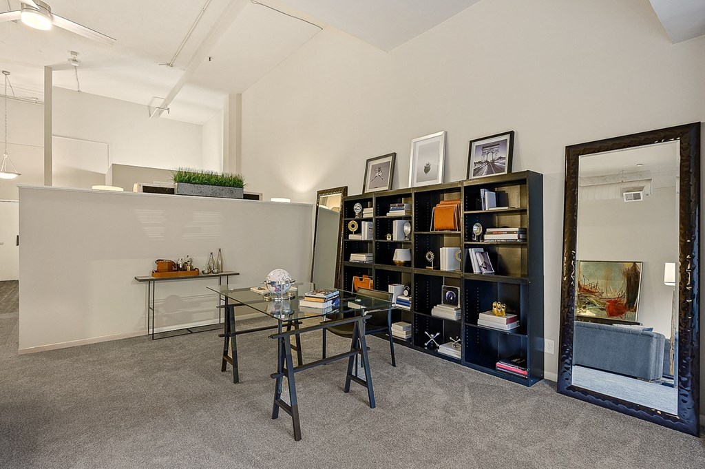a room with a table and a mirror and a bookshelf