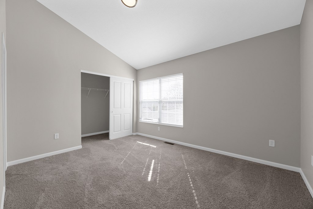 an empty living room with a door to a closet and a window at Traditions at Slate Ridge, Reynoldsburg, 43068