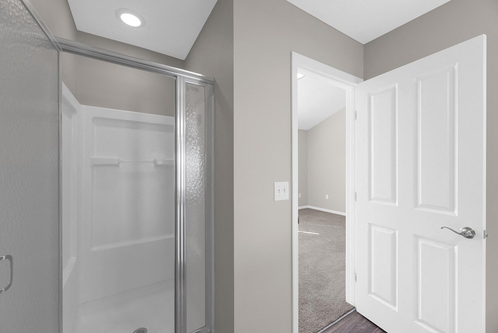 a bathroom with a glass shower and a door to a closet at Traditions at Slate Ridge, Reynoldsburg 