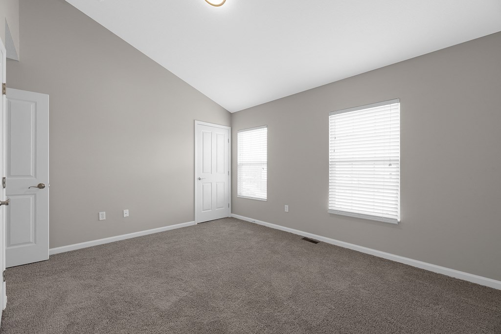 an empty living room with a door and two windows at Traditions at Slate Ridge, Reynoldsburg Ohio