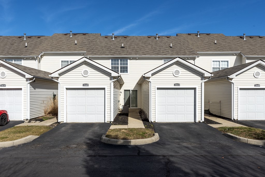 a row of houses with white roofs and garages at Traditions at Slate Ridge, Reynoldsburg