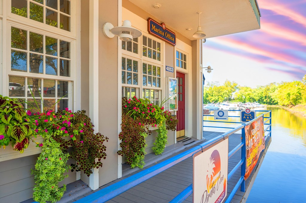 the front porch of a restaurant with a river in the background