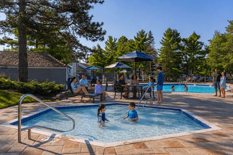 A group of people are enjoying a sunny day at a poolside.
