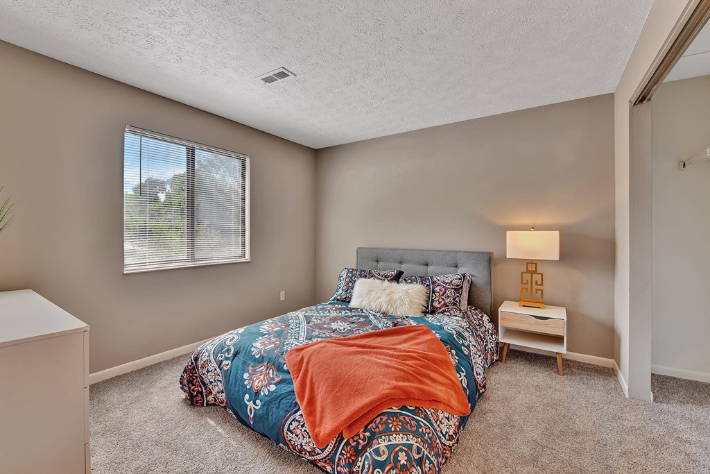 a bedroom with a bed and a window