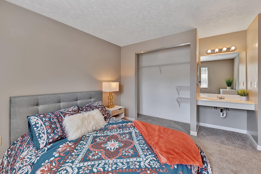 a bedroom with a bed and a bathroom with a sink