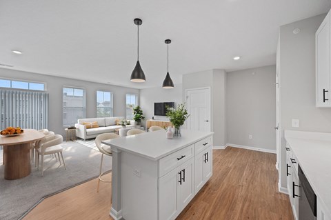 A modern kitchen with white cabinets and a wooden island. at Monmouth Row Apartments, Newport, KY, 41071