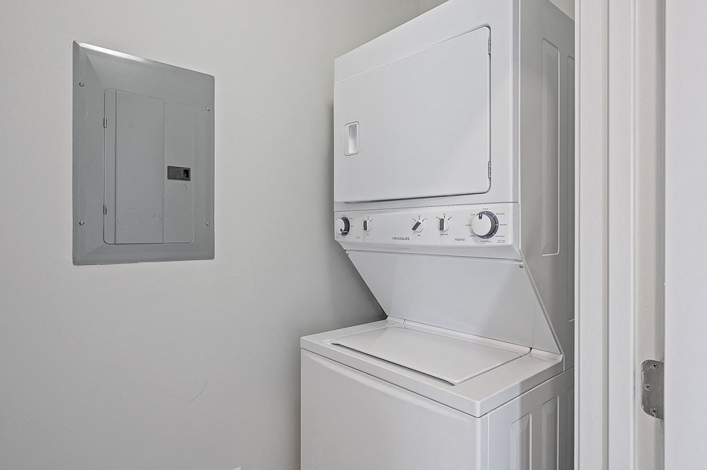 a white washer and dryer in a white laundry room with a white door at Monmouth Row Apartments, Newport, 41071