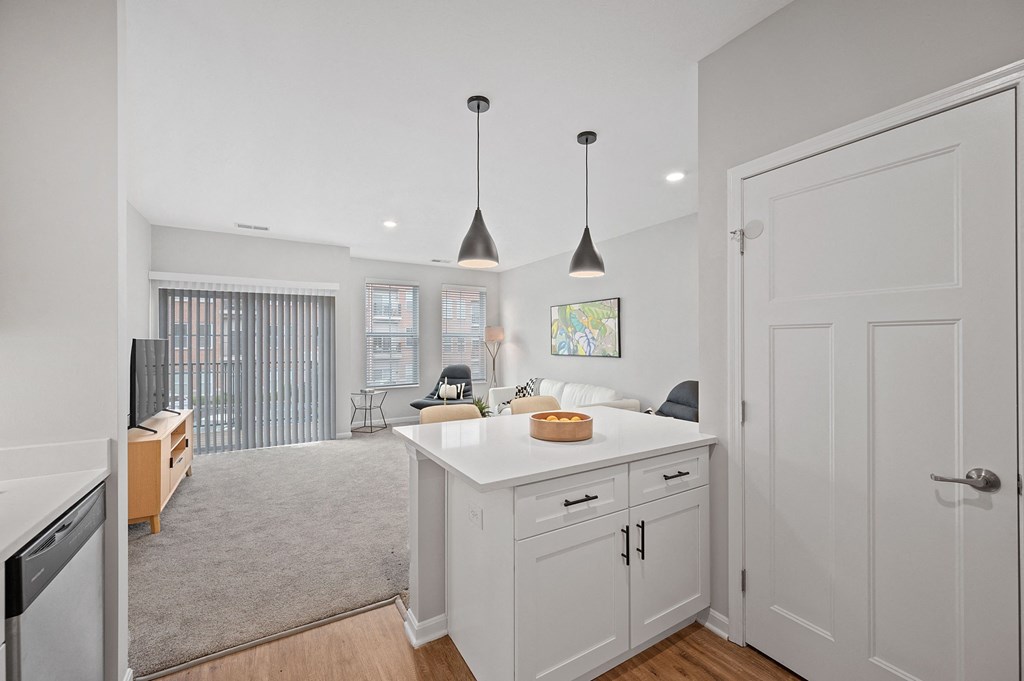 an open kitchen and living room with white cabinets and a white counter top at Monmouth Row Apartments, Newport, Kentucky