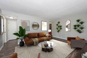 Living room with a brown couch and a coffee table  at Williams Pointe, Williamsburg - Photo Gallery 4