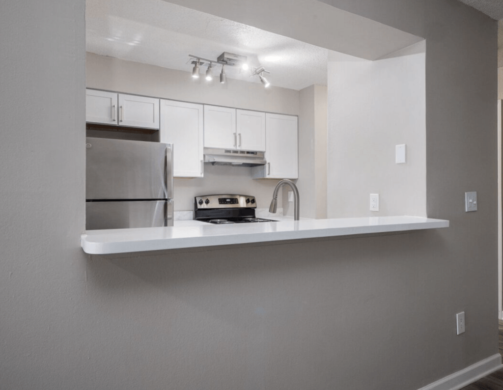 a kitchen with white cabinets and a sink and a refrigerator at The Berryessa Apartments, Ohio, 98104