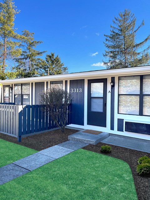 the front of a building with windows and a lawn