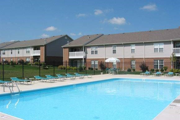 A swimming pool in front of apartment buildings.