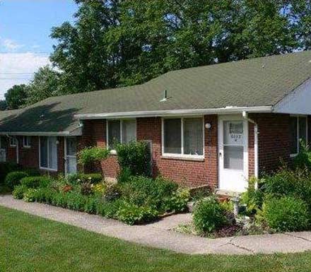 a brick house with a garden in front of it