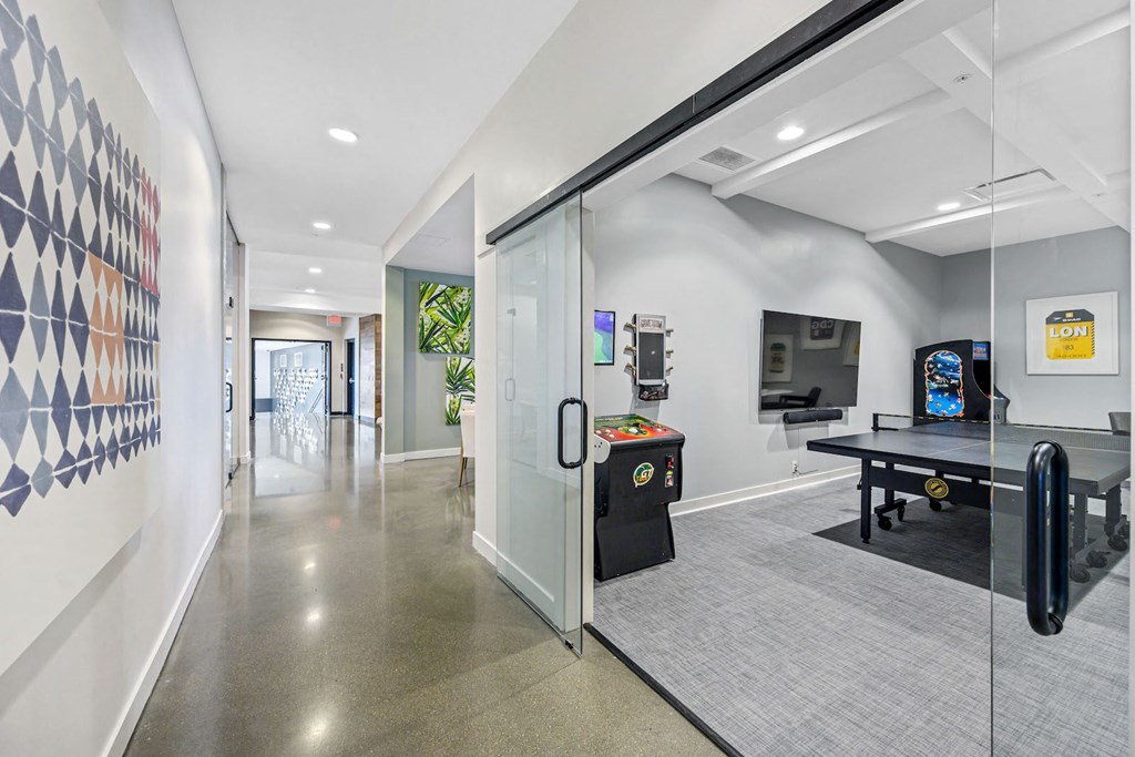 Two-Bedroom Apartments in West Chester, OH - Liberty Center - Gameroom with Ping Pong Table, Arcade Games, and a Mounted Television