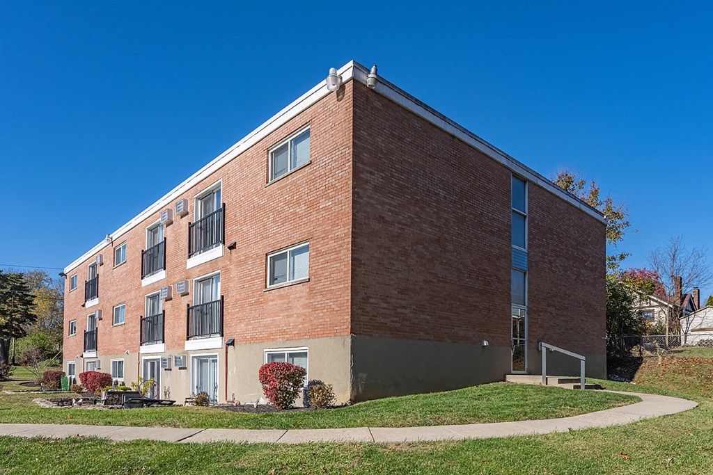 a brick building with a sidewalk in front of it