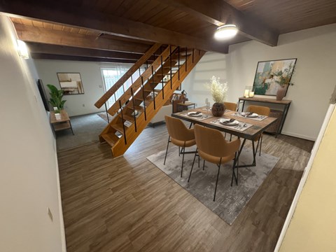 Dining room with wooden staircase and exposed beams at Rivers Edge Apartments and Townhomes, Dayton, OH 45405