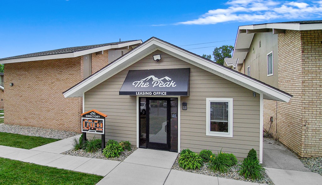the desk building entrance with sidewalk and grass