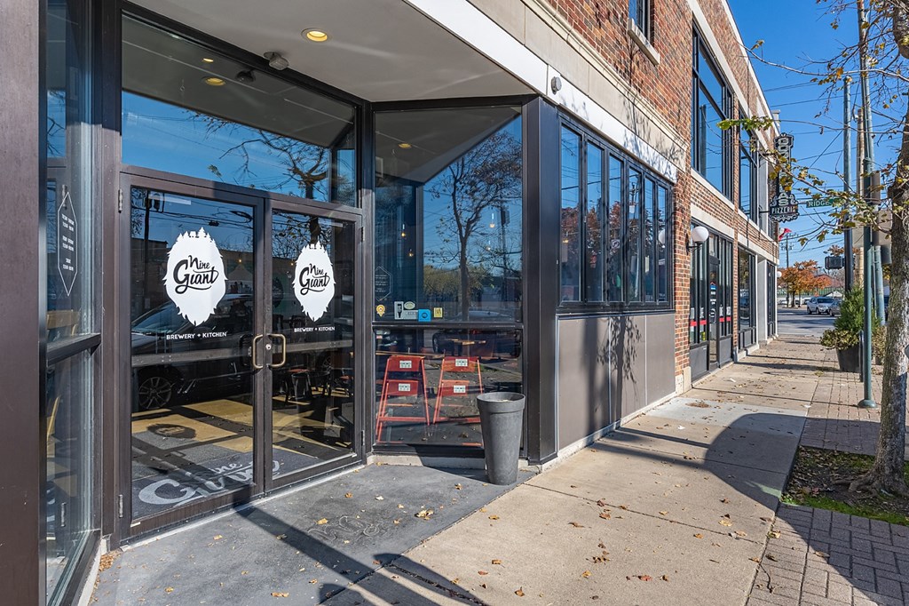 a store front with glass doors and a sidewalk