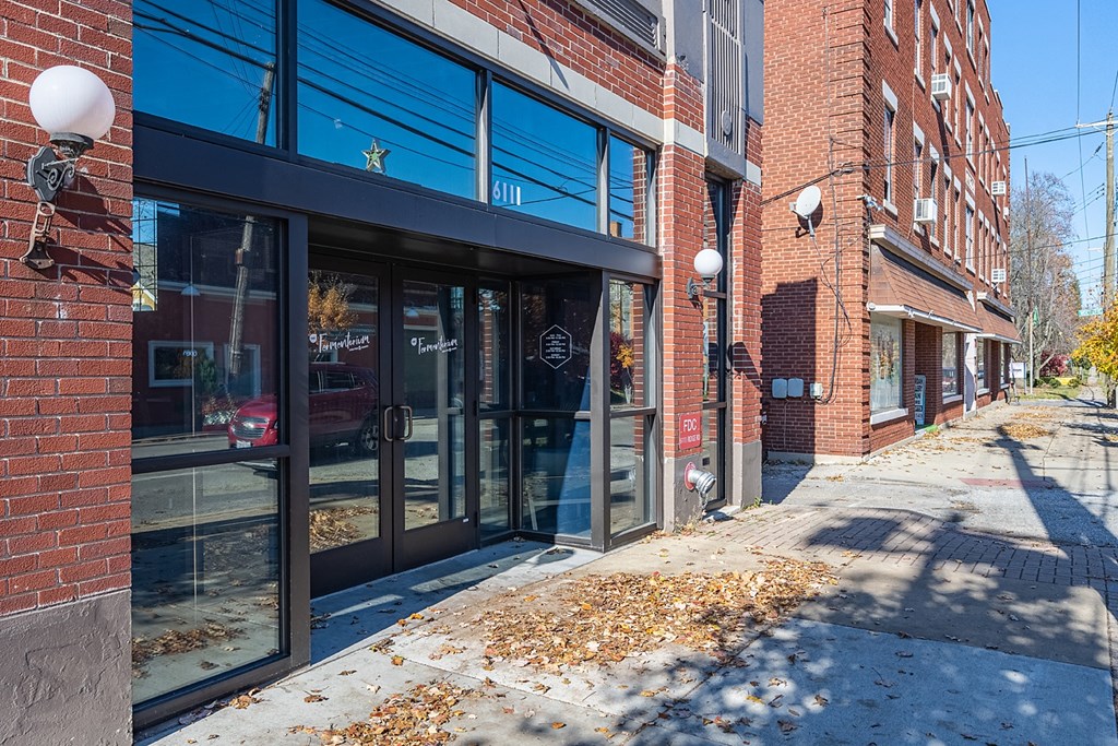 a city street with a brick building with glass doors